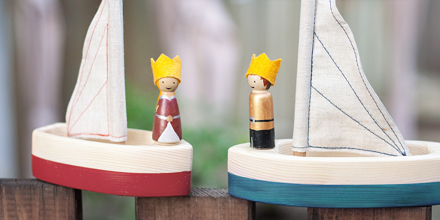 painted peg people on toy sailboats