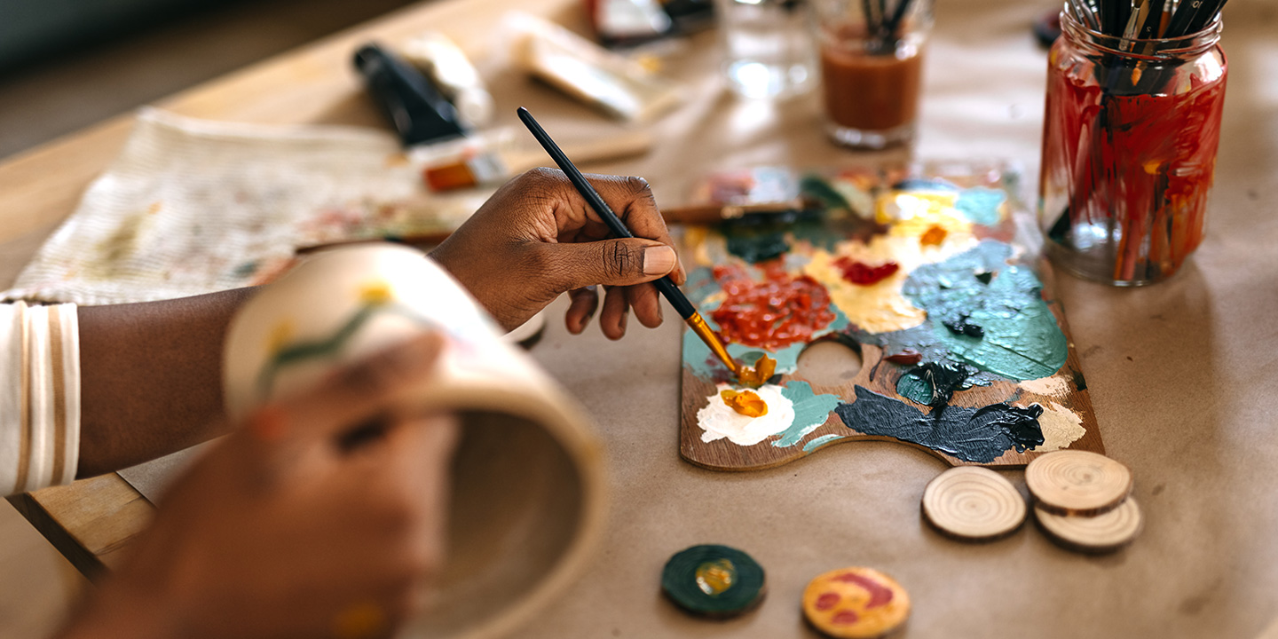 person painting wood crafts